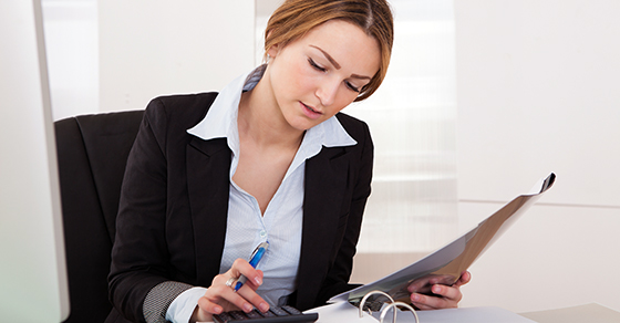 Businesswoman reading contents of binder