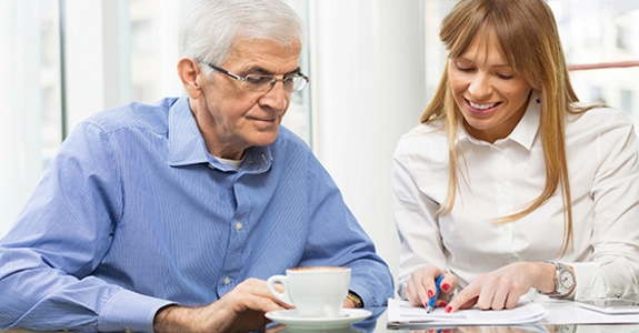 Man and woman looking at financial paperwork at table.