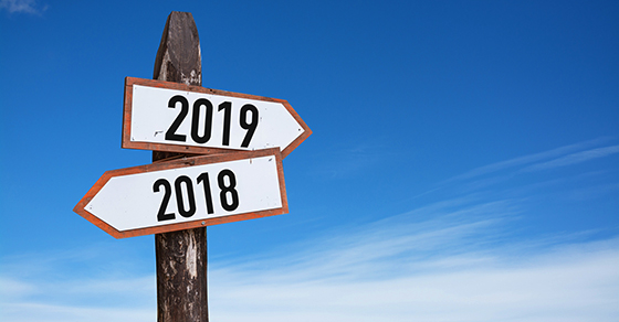 New Year wooden road sign with shining blue sky background