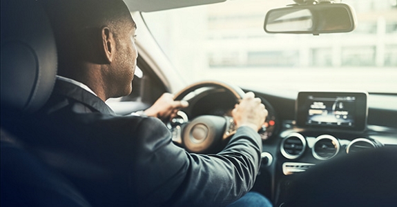 Over-the-shoulder view of man driving car