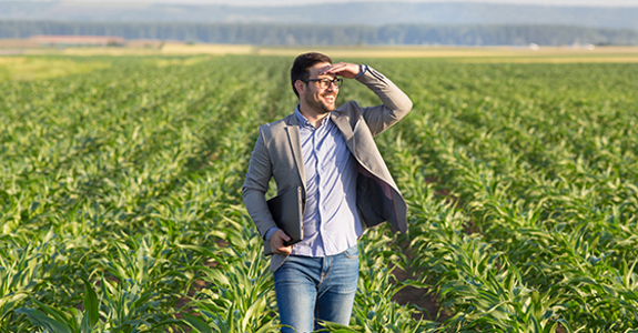 Man looking off in the distance while standing on farmland