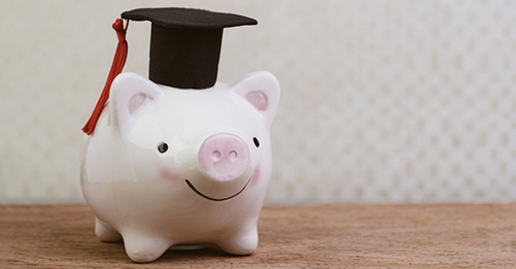 Piggy bank with graduation cap on its head
