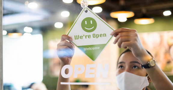 Person in mask advertising that business is open