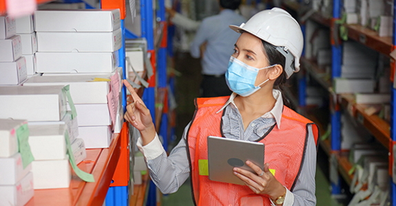 Worker wearing PPE and checking inventory